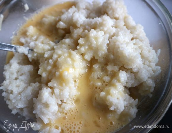 Яйца перемешать венчиком. Добавить к остывшему рису. Перемешать. Можно добавить вместо 2 яиц 1 яйцо и 1 желток, тогда убавьте немного количество риса. У меня немного риса осталось после приготовления запеканки. Если у вас есть форма немного побольше, скажем, на 1,8 литра, можете использовать ее.