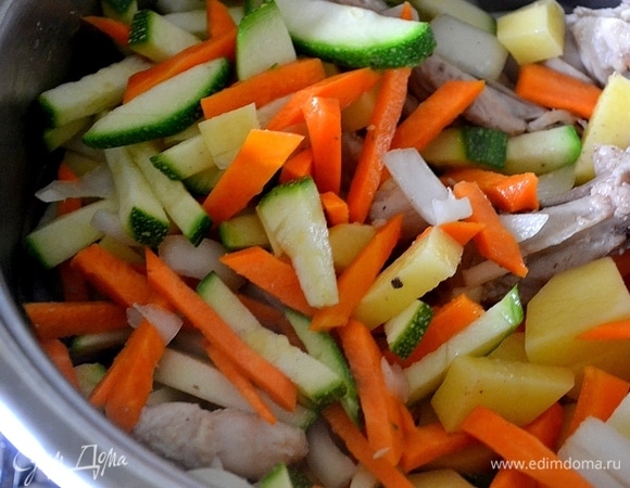 На курицу выкладываем все нарезанные овощи. Заливаем крутым кипятком и варим до готовности картофеля.