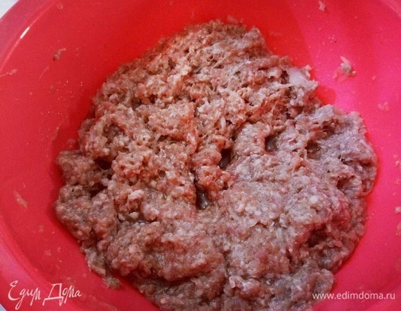 Пока тесто стоит в холодильнике, подготавливаем начинку. В фарш добавляем соль, перец, воду и лук. Лук можно натереть на терке. Все тщательно перемешать. Начинка по консистенции должна напоминать жидкую кашу.