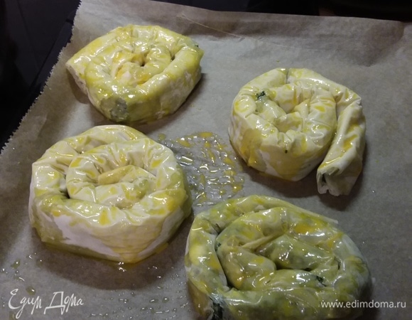 Выложить улитки на противень, покрытый пергаментной бумагой. Смазать желтком и запекать в заранее разогретой до 180°C духовке около 30 минут.