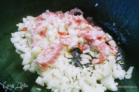 В этой же сковороде обжарить лук, чеснок, перец чили и бекон (все предварительно мелко нарезать).
