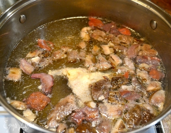 У меня целая курица. Отделяем куриную грудку, для бульона — крылья и спинку. Ставим кастрюлю с водой на огонь и отвариваем куриные части для бульона. Когда курица готова, достаем спинку и добавляем грибы.