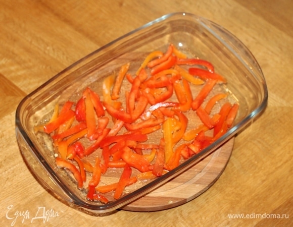 Сладкий перец запекаем в духовке или микроволновке. Затем кладем в пакет, остужаем и очищаем от шкурки и семян, нарезаем небольшими полосками. Форму для запекания смазываем растительным маслом и кладем в нее сладкий перец.
