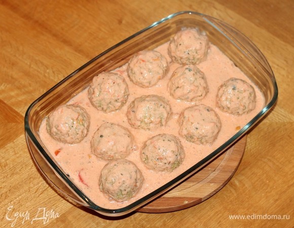 Поливаем фрикадельки приготовленным соусом, посыпаем тертым сыром. Украшаем вялеными помидорчиками (это по желанию). Накрываем формочку неплотно фольгой и отправляем в разогретую до 180°C духовку на 30 минут.