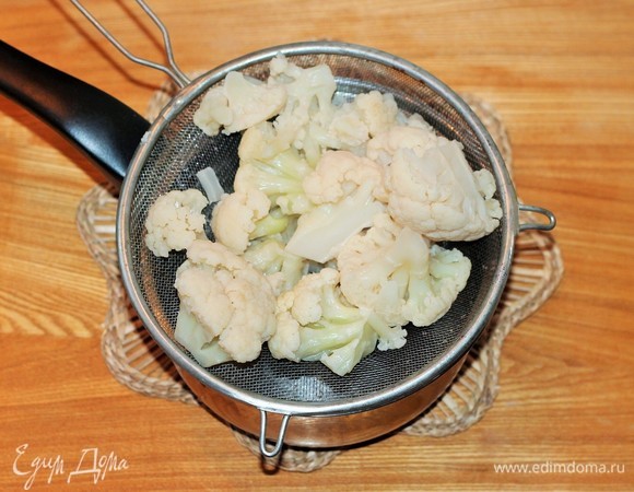 Цветную капусту, не размораживая, загрузить в кипящую подсоленную воду и варить до готовности минут 10. Затем воду слить.