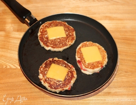 Смазываем (всего лишь каплей масла) один раз сковороду растительным маслом и хорошо разогреваем. На разогретой сковороде выпекаем котлетки-лепешки с двух сторон. Переворачиваем и на обжаренную сторону кладем пластину сыра (1/4 часть), допекаем вторую сторону. Без масла котлетки выпекаются очень быстро. С маслом становятся вязкими.