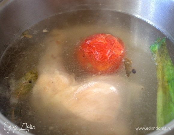 Ставим вариться бульон. Первую воду я сливаю и с курицы снимаю кожу. Далее — свежая вода, лаврушка, перец, соль. Помидор добавляем по желанию, у меня переспелый (в сезон, когда не успеваем съедать, кидаю в морозилку для бульонов).