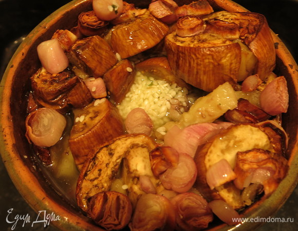 Достаем горшок и делаем отверстие между мясом и луком. Засыпаем промытый рис посередине, в отверстие.