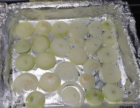 Дно большого противня с высокими краями (сока будет много) выстилаем фольгой, поверх нее толстенькими колечками лук выкладываем.