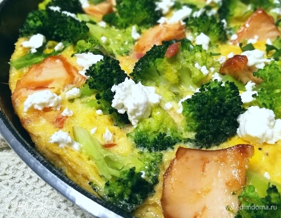 Горячую фриттату посыпать раскрошенной фетой и свежей зеленью.