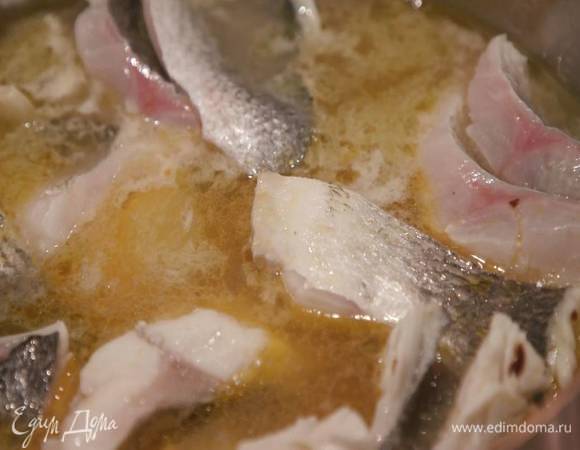 Приготовить соус: разогреть в тяжелой сковороде 1 ст. ложку оливкового масла и слегка обжарить нарезанный чеснок и раскрошенный руками пеперончино, добавить рыбу, влить белое вино и дать алкоголю немного выпариться, затем влить горячий бульон, так чтобы все было покрыто жидкостью, и прогревать еще несколько минут.