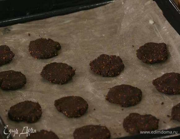 Противень выстелить бумагой для выпечки и смазать ее оставшимся сливочным маслом, сформировать из теста небольшие лепешки и выложить на противень.