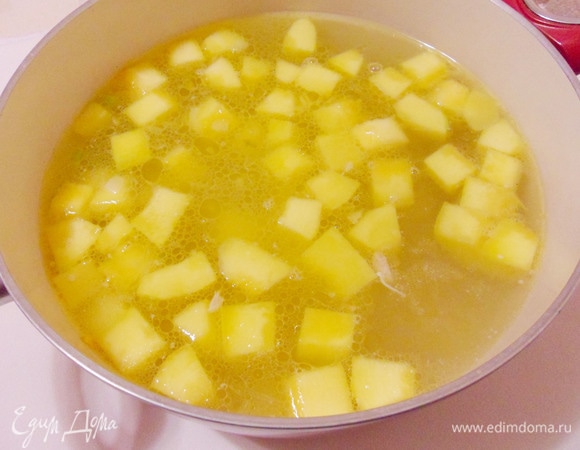 Выложить овощи в кастрюлю с кипящим бульоном, добавить кусочки курицы и варить около 10 минут.