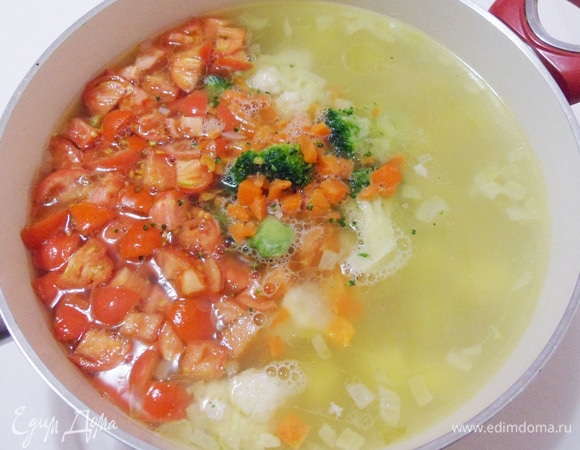 Добавить в суп овощную смесь «Царский салат», измельченные помидоры. Посолить. Дать закипеть и варить суп около 5 минут.