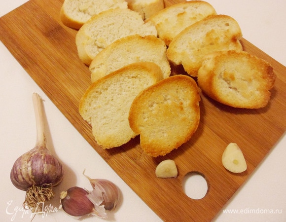 Затем обжаренные кусочки багета щедро натереть чесноком.