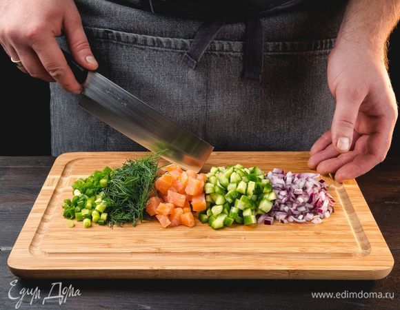 Филе лосося нарежьте мелкими кубиками. Очень мелко порубите огурцы, красный и зеленый лук, укроп.