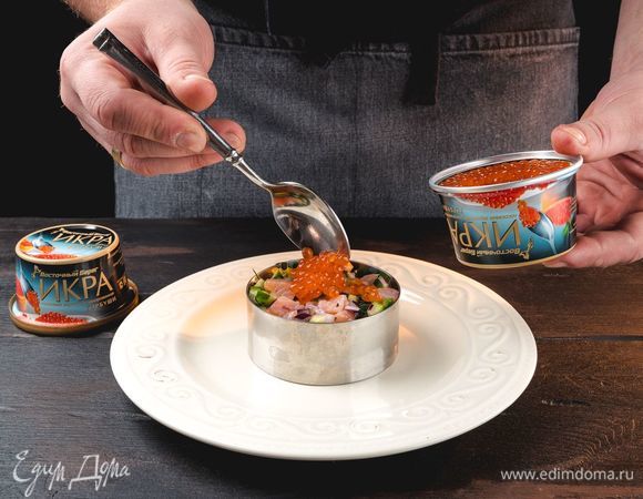 Готовый тартар разложите на тарелки в виде небольших круглых башенок с помощью сервировочного кольца. Сверху каждой порции выложите слой красной икры «Восточный берег».