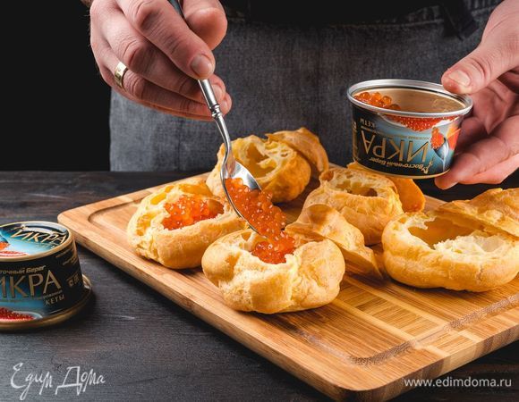 Срежьте верхушку у профитролей. В каждую профитроль положите красную икру «Восточный берег».