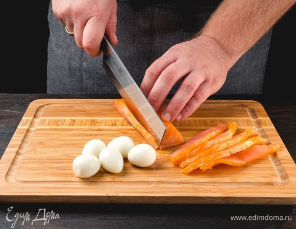 Отварите перепелиные яйца, очистите от скорлупы. Рыбу нарежьте тонкими слайсами.