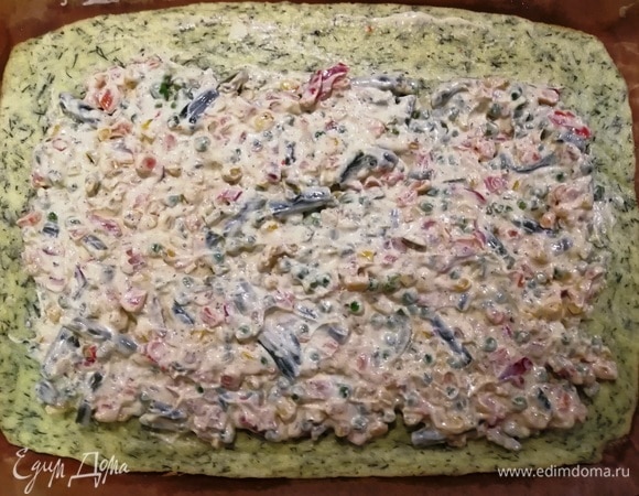 Вынимаем корж из духовки, переносим на пергаменте на рабочую поверхность. На горячий корж выкладываем начинку.