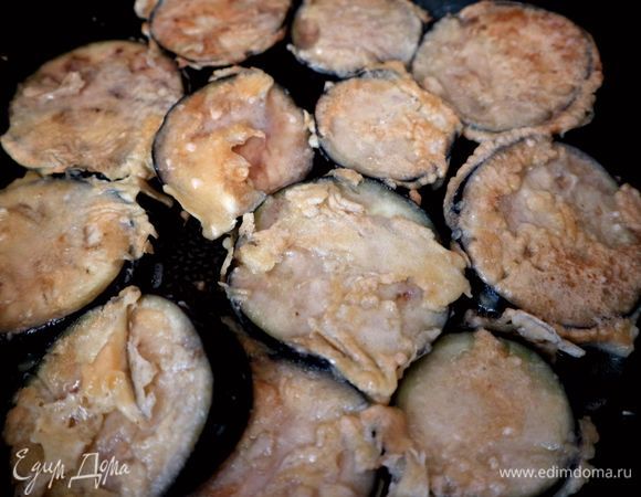 Каждый кусочек баклажана обмакнуть в яичную смесь, поместить на разогретую с оливковым маслом сковороду. Обжарить с двух сторон. Поместить на бумажную салфетку, чтобы удалить лишнее масло.