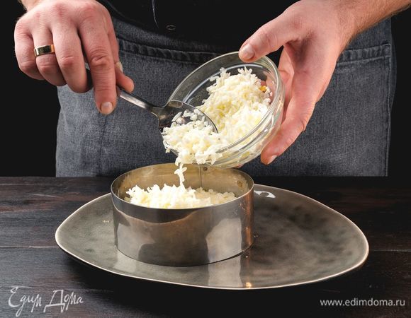Затем выложите поочередно тертый белок, лук, затем — тертый желток. Смажьте слои майонезом по вкусу.