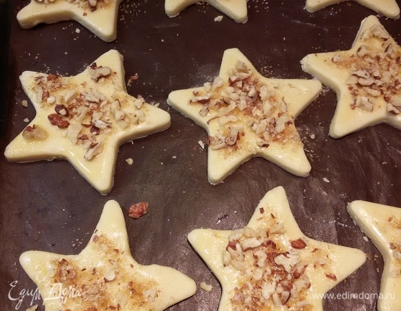 Раскатать тесто толщиной примерно 0,5 см. Вырезать тесто любой формой, которая вам нравится. Переложить коржики на противень, смазать верх яйцом и посыпать орехами с сахаром. Выпекать 12 минут при 180°C.