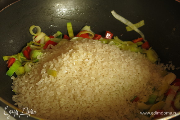 Насыпаем рис к овощам. 2 минуты обжариваем до прозрачности риса.