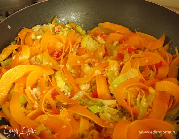 Добавляем тыкву к рису с овощами, обжариваем еще минуту.