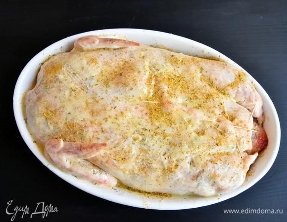 Кожу начинить подготовленным фаршем. Скрепить зубочистками места разрывов. Тушку смазать растопленным сливочным маслом, посолить и посыпать специями, например, готовой приправой для курицы. Выложить в форму для запекания.