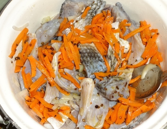 Достать рыбу из холодильника. Отлить половину маринада, он больше не понадобится. Добавить к рыбе с луком морковь с пряностями, перемешать и поставить в холодильник еще на пару часов.