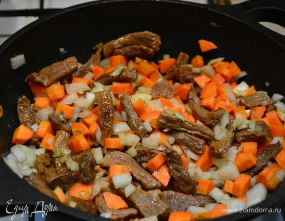 Добавляем крупно нарезанные морковь, лук. Накрываем крышкой и оставляем тушиться около 1 часа на медленном огне, при необходимости добавляем воду, чтобы не пригорело.