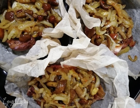 На свинину выкладываем грибы. Отправляем в разогретую до 180°С духовку на 50 минут.