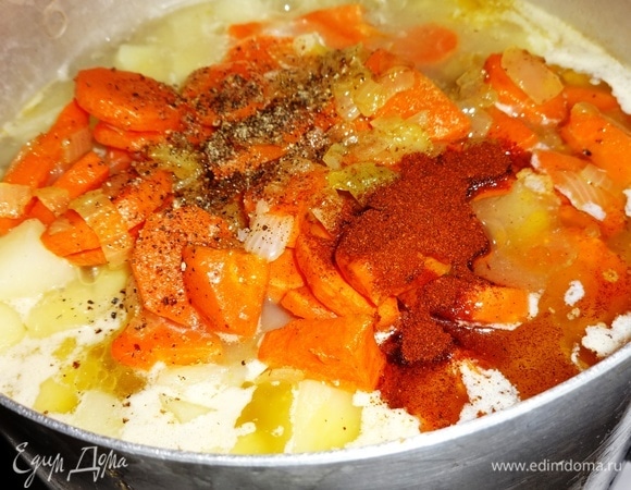 Обжаренные лук и морковь добавить к картофелю. По вкусу посолить, поперчить, всыпать паприку, перемешать.