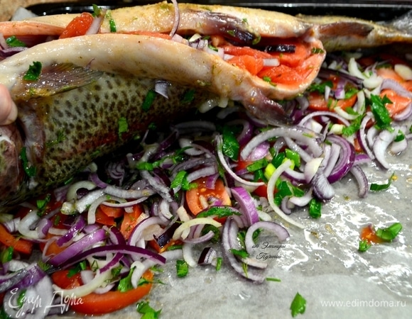 Нарезанный полукольцами лук, помидор, зелень посолить и перемешать. У нас готова замечательная сочная начинка для наполнения рыбы и «подушка» под саму рыбу, которая в процессе приготовления отдаст весь аромат и вкус рыбе. Лимон подается к красной рыбе при подаче. Если полить красную рыбу соком лимона во время приготовления, она потеряет свой цвет.