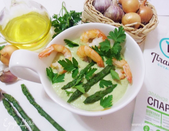 Подавать суп в глубоких мисках, сверху выложить обжаренные креветки и спаржу. Посыпать зеленью петрушки.