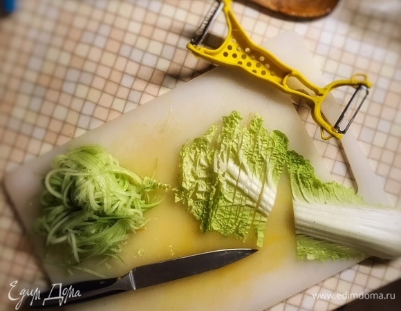 Очистите огурец от кожуры и нашинкуйте таким же способом, что и морковь, удалив при этом семенную часть. Листья салата нарежьте тонкими полосками. Красный лук тонко нарежьте кольцами или полукольцами. Выложите остальные овощи к моркови с перцем. Перемешайте и снимите с огня.