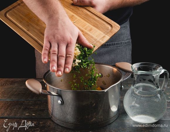Добавьте воду, зелень, пряности и мелкорубленый чеснок. Варите на слабом огне, пока тыква не станет мягкой. В конце варки все вместе измельчите с помощью погружного блендера.
