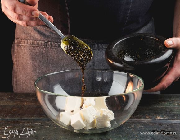 Нарежьте сыр кубиками по 0,5 см и залейте смесью из семечек и масла.