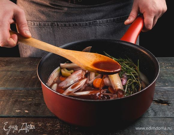 Добавьте к овощам томатную пасту и розмарин, влейте вино в сковородку, продолжайте жарить.