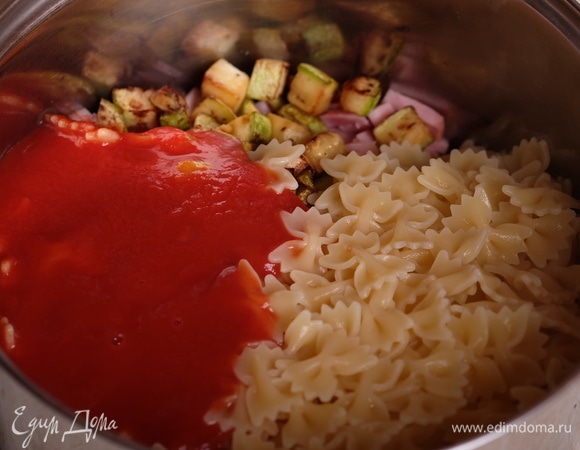 В отдельной емкости смешать вместе отваренную пасту, обжаренные кабачки, томаты и ветчину.