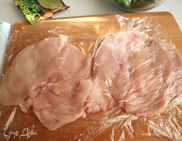 Поместить филе куриных грудок между листами пищевой пленки, отбить аккуратно, стараясь не порвать кусочки филе.