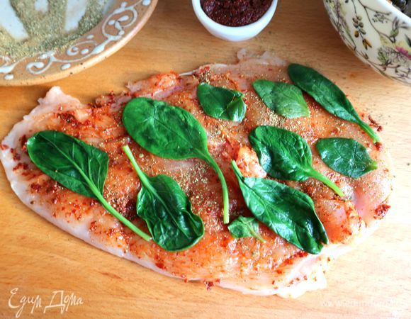 Поместить бланшированные листочки шпината на куриное филе.