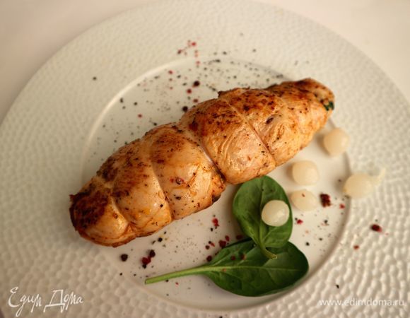 Снять кулинарную нить, на тарелку поместить несколько листиков шпината, молотый черный и розовый перцы, маленькие маринованные луковки.