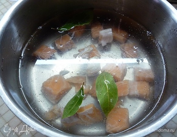 В кастрюлю наливаем 3 л воды и доводим до кипения. Филе лосося нарезаем средними кусочками и кладем в кастрюлю с водой. Добавляем лавровые листики.