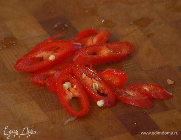 Перец чили вместе с семенами порезать наискосок тонкими кольцами.
