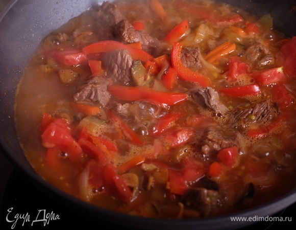 Добавить помидоры и влить кипяток так, чтобы вода почти покрыла овощи с мясом. Добавить перец чили, посолить при необходимости.