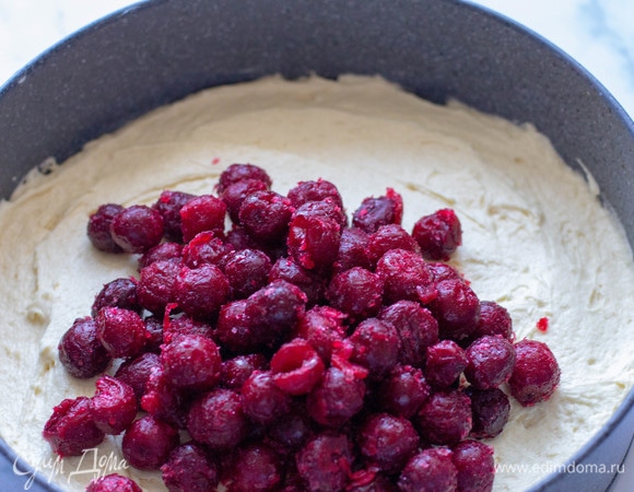 Сверху теста выложить предварительно размороженную вишню.