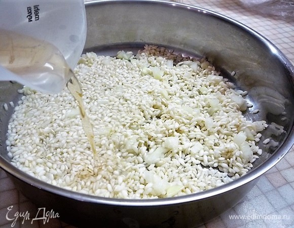 Вливаем вино и даем полностью ему выпариться. Затем частями вливаем теплый бульон, солим и перчим по вкусу. Как только первая часть бульона выпарится, добавляем следующую.