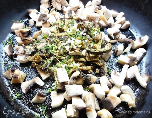 На другой сковороде разогреваем оливковое масло, выкладываем мелконарезанные шампиньоны, добавляем белые грибы, мелконарезанный зубчик чеснока и веточки тимьяна, солим и перчим по вкусу. Накрываем крышкой и тушим 5–7 минут. Можно добавить воду, в которой были замочены белые грибы, только осторожно: на дне чашки может быть немного песка от грибов.